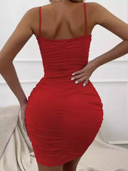 Back view of a model wearing the red mini dress, with thin straps and dense ruching.