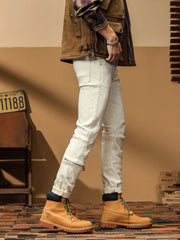 Side view of off-white slim-fit jeans showing knee panels and a lower-leg zip