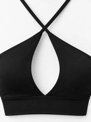 Close-up of black halter crop cami showing crossed straps and front cutout