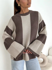 Model standing in cream and taupe oversized sweater with long wide sleeves