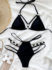 Black cutout halter bikini set arranged flat, front view with sandals