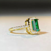 Side profile of a raised green rectangular stone in a gold-tone setting.