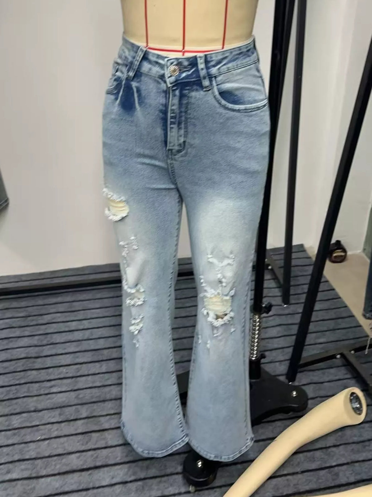 Light blue distressed wide-leg jeans displayed on a dress form, front view