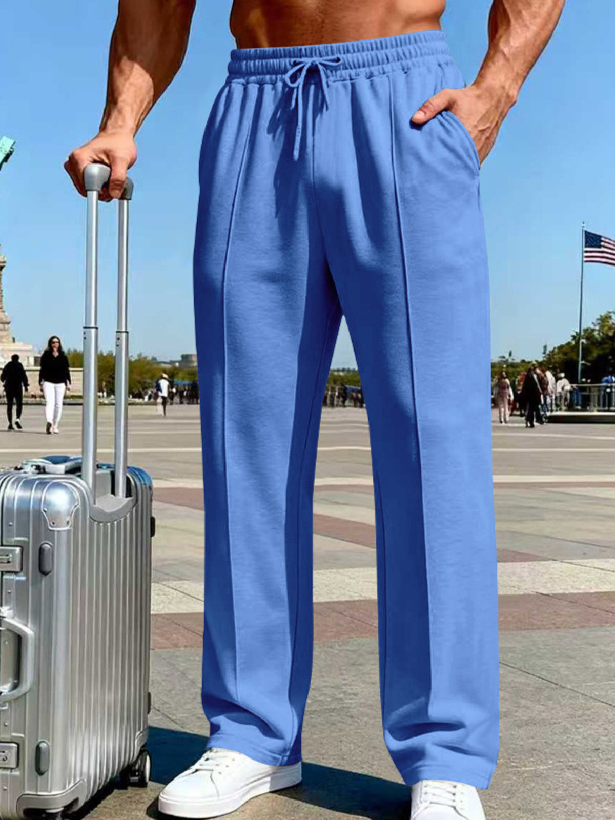Front view of blue wide-leg pants with drawstring waist beside a suitcase.
