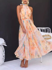 Model in pastel floral halter-neck maxi dress with gathered waist