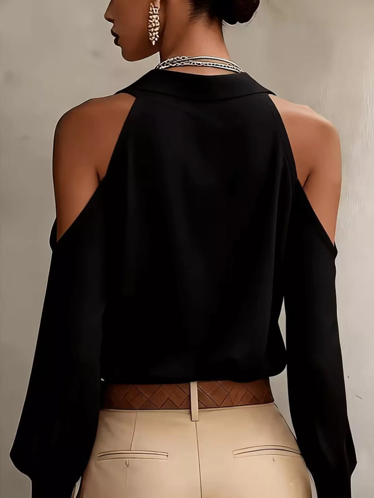 Back view of black blouse showing open shoulder detail.