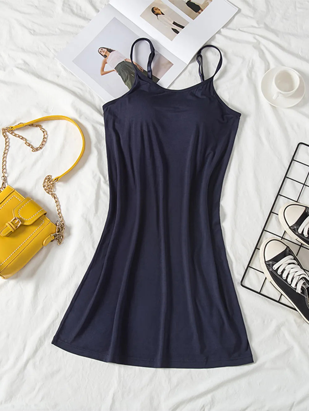 Dark navy cami dress laid flat with a fitted bodice and flared skirt