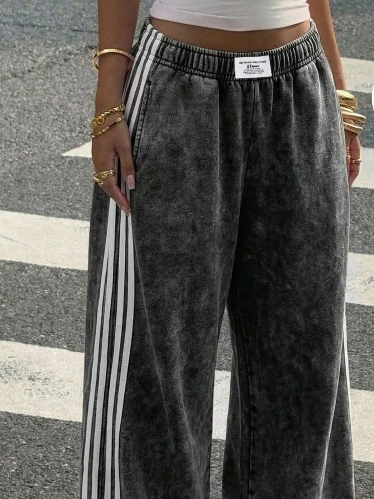 Front view of charcoal track pants with white side stripes