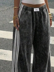Front view of charcoal track pants with white side stripes
