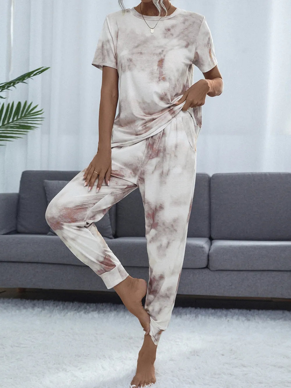 Model poses in a pale tie-dye short-sleeve top and matching pants