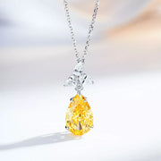 Light-yellow teardrop zircon pendant with a clear-stone accent on a silver-tone chain