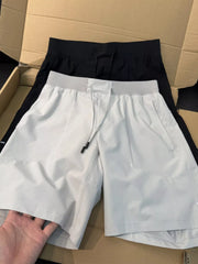 White athletic shorts held open to show elastic waistband