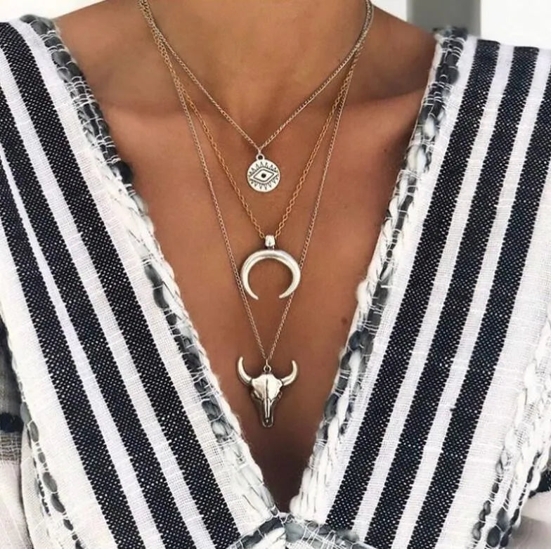 Model wearing the gold-tone layered bull head necklace with a striped top