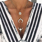 Model wearing the gold-tone layered bull head necklace with a striped top