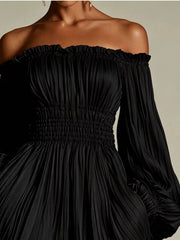 Model wearing the black version of the off-shoulder pleated mini dress