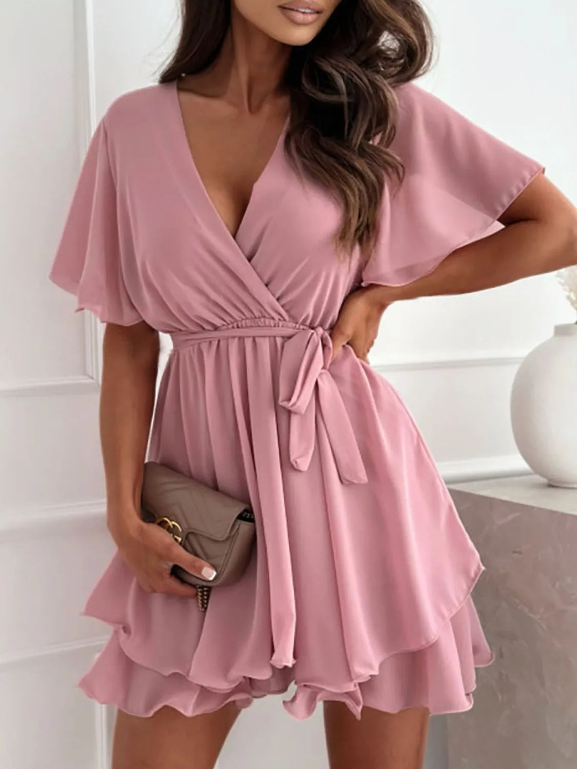 Model in dusty pink surplice flutter-sleeve ruffle mini dress