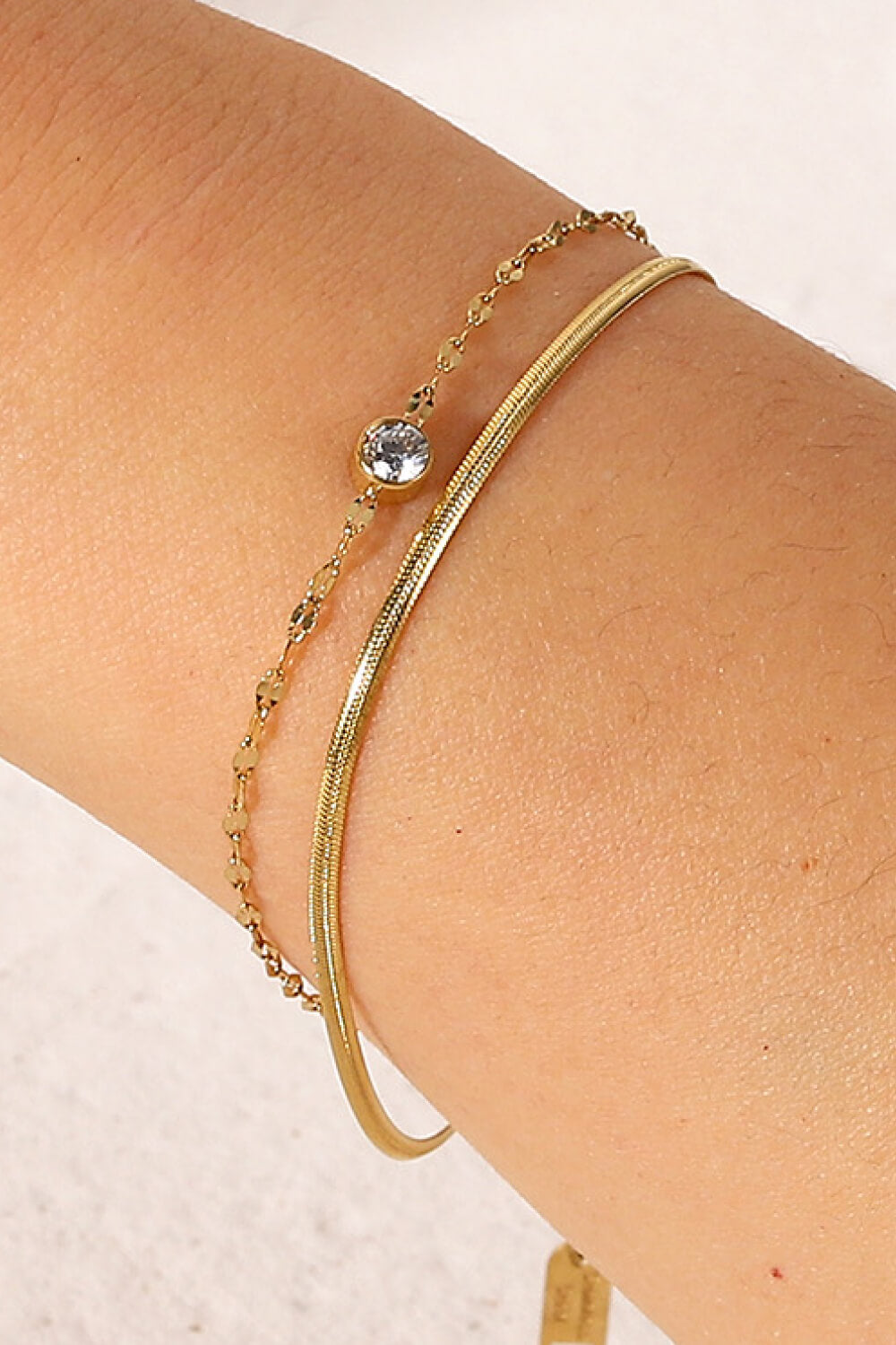 Gold double-layer bracelet arranged on a wrist