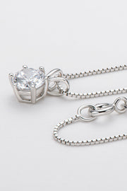 Side close-up of a silver-tone solitaire pendant showing its raised setting and chain