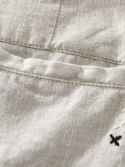 Close-up of white shorts pocket and small embroidered mark