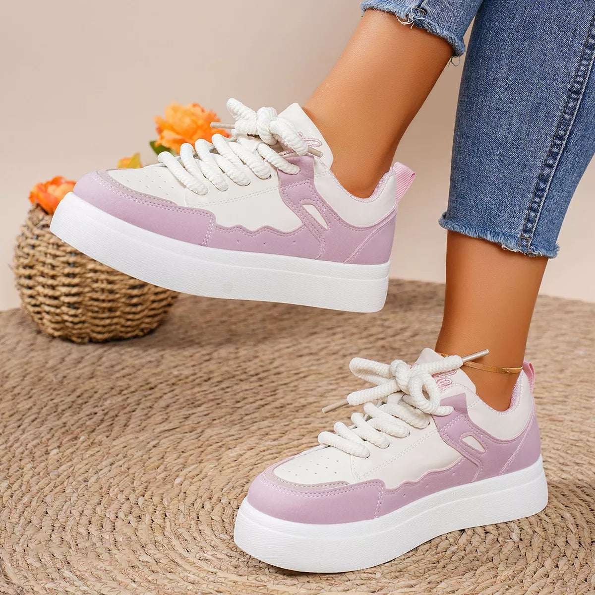 Pink and white platform sneakers worn with jeans
