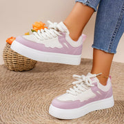 Pink and white platform sneakers worn with jeans