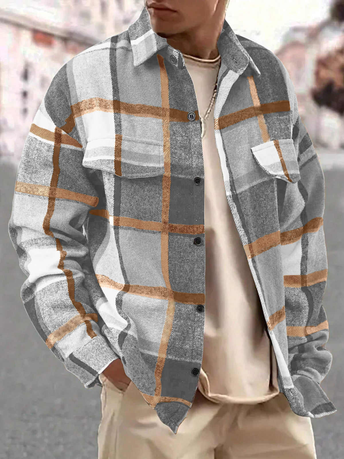 Model wearing the gray and tan plaid shirt over a light top