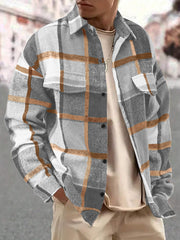Model wearing the gray and tan plaid shirt over a light top