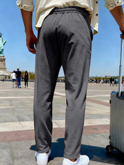 Back view of charcoal gray wide-leg pants in a Paris plaza.