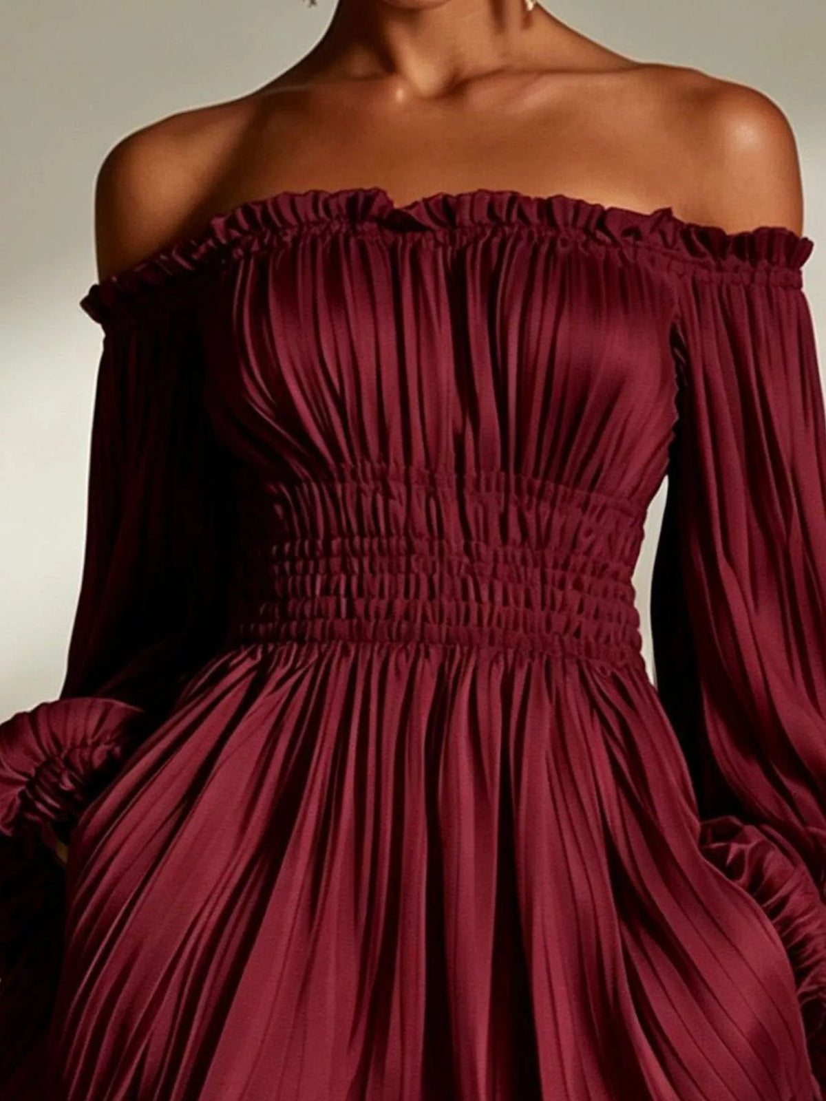 Model wearing the burgundy version of the pleated off-shoulder dress