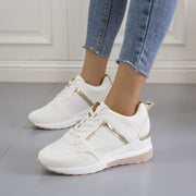 Pair of white lace-up wedge sneakers worn with jeans