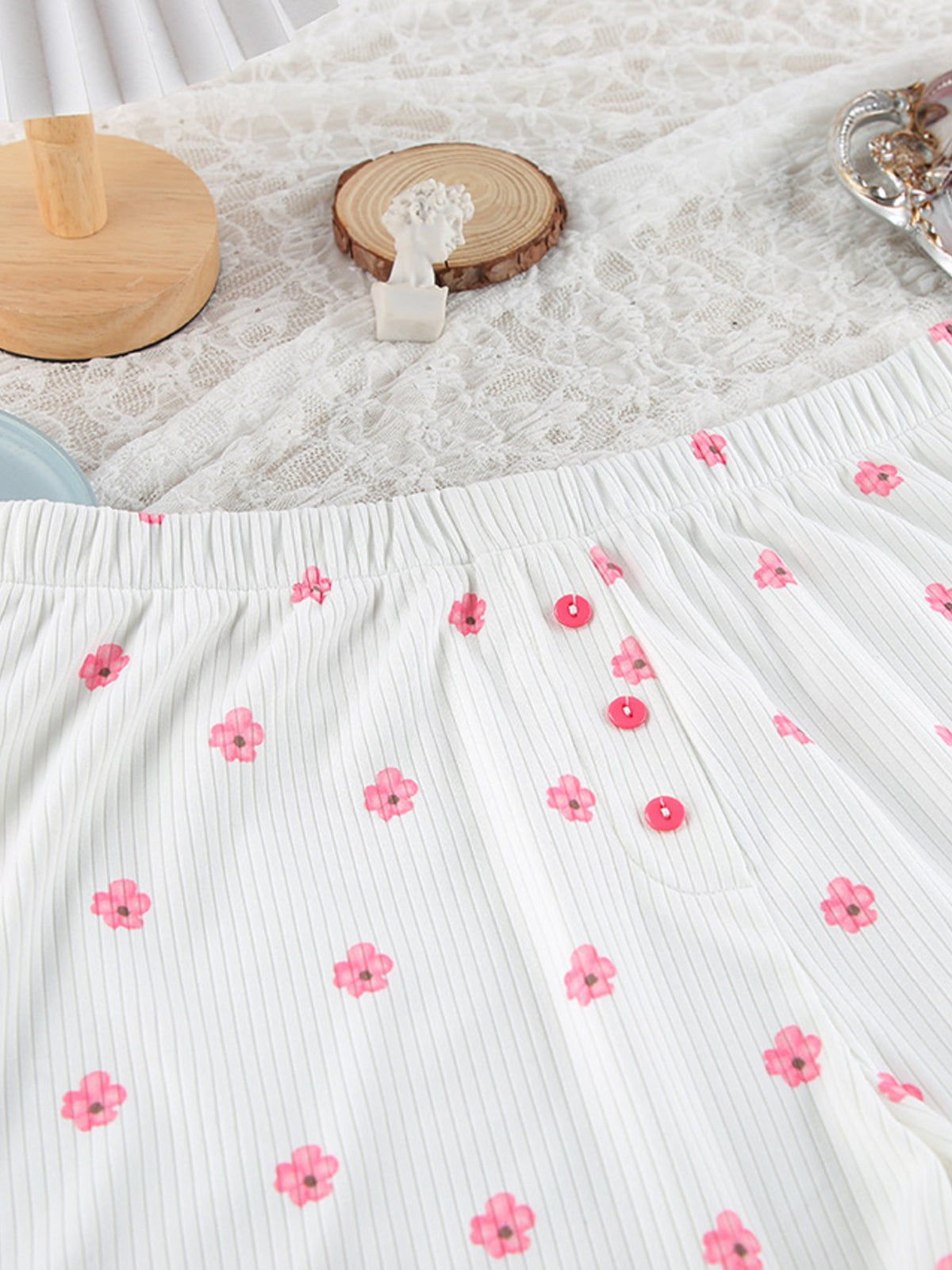 White lounge shorts with pink flower print and decorative front buttons