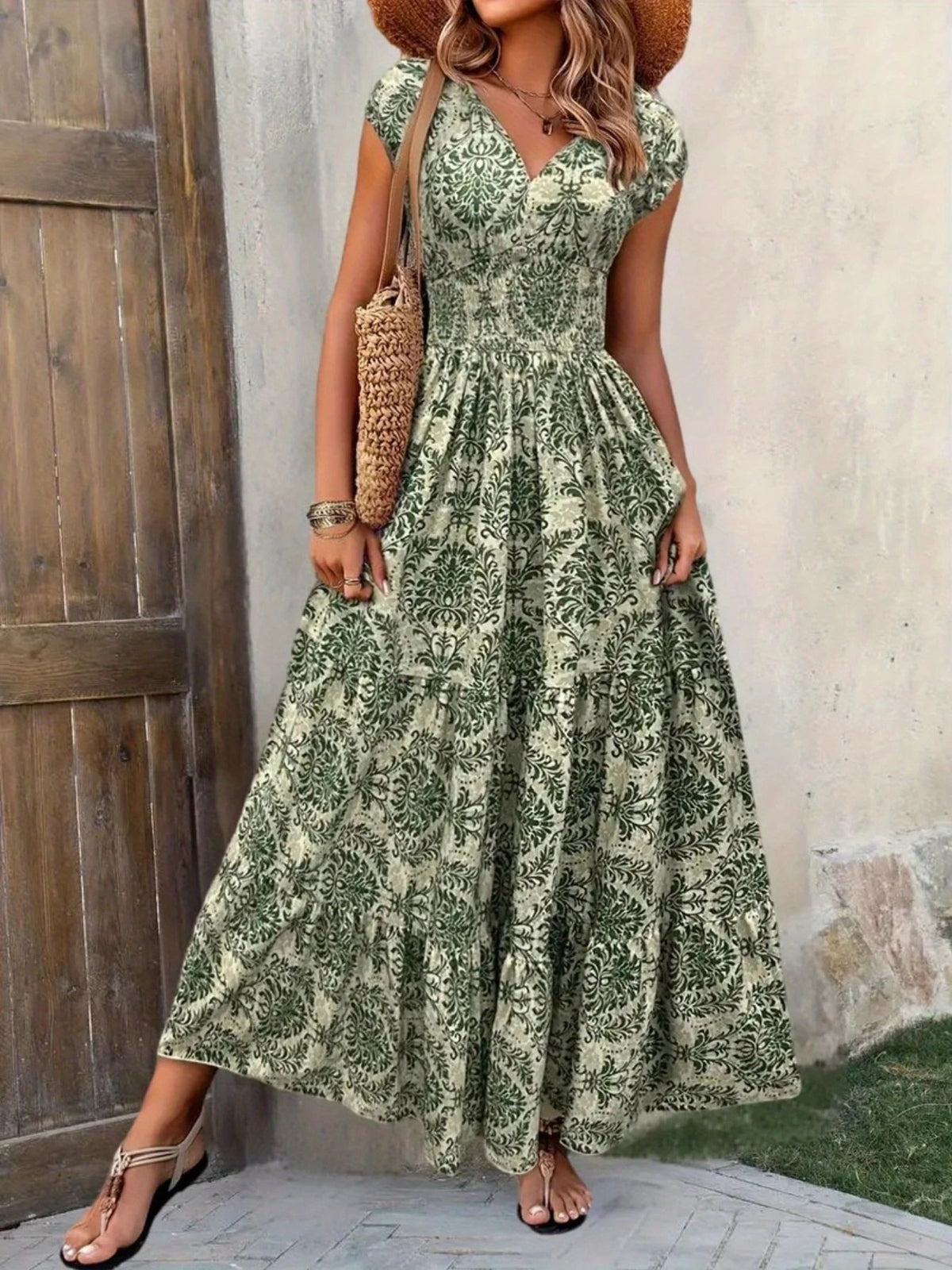 Front view of green floral cap-sleeve maxi dress showing the V-neck, smocked waist and tiered skirt.