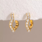 Close-up of the square zircon accents on gold-tone hoop earrings