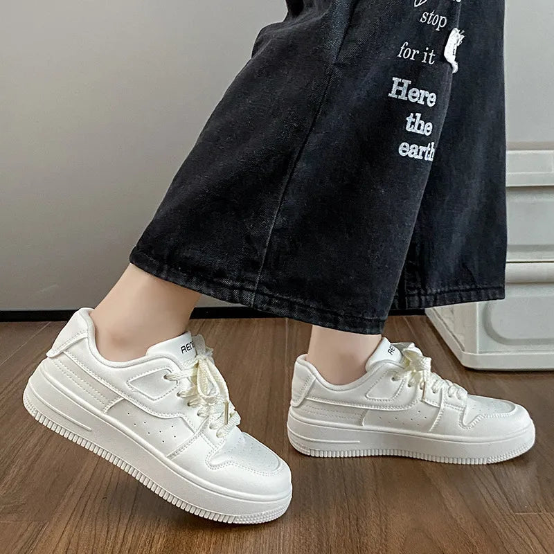 White lace-up platform sneakers worn with black wide-leg jeans, angled front view