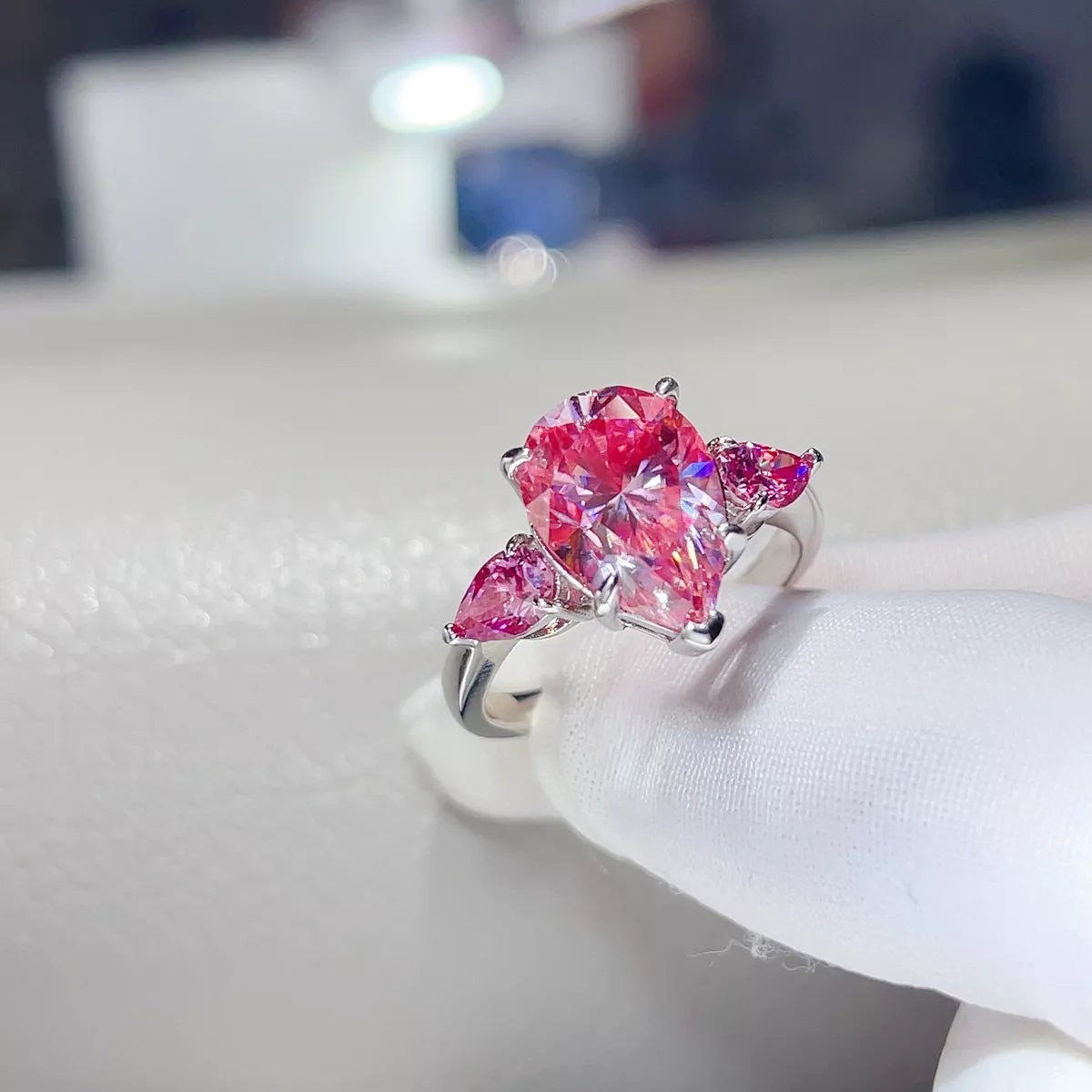 Angled close-up of the pink teardrop ring and its silver setting