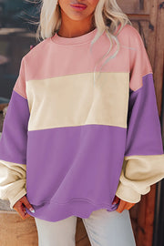 Model wearing pastel color-block sweatshirt with jeans