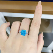 Pastel blue rectangular zircon ring worn on a hand, showing the baguette side stones