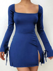 Front studio view of the blue fitted mini dress with flared tie cuffs and a skirt slit.