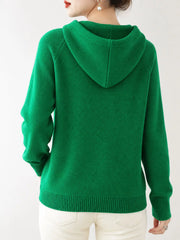 Back view of the emerald green knit sweater showing its hood and ribbed hem.
