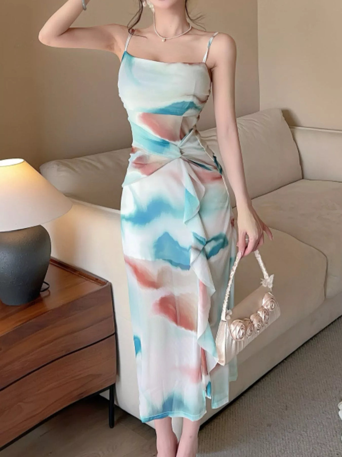 Model wearing a teal and coral watercolor-print midi dress with a side slit.