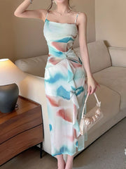 Model wearing a teal and coral watercolor-print midi dress with a side slit.