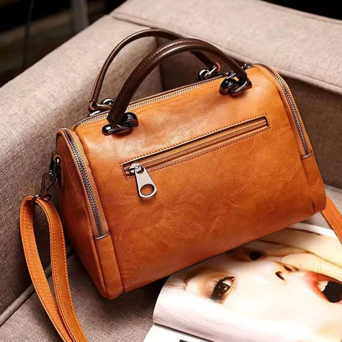 Rear of tan flap bag with a horizontal zip pocket