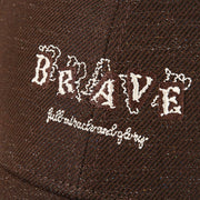 Close-up of white embroidered lettering on the brown baseball cap