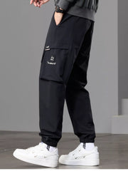 Side view of black joggers showing the thigh cargo pocket and tapered leg.