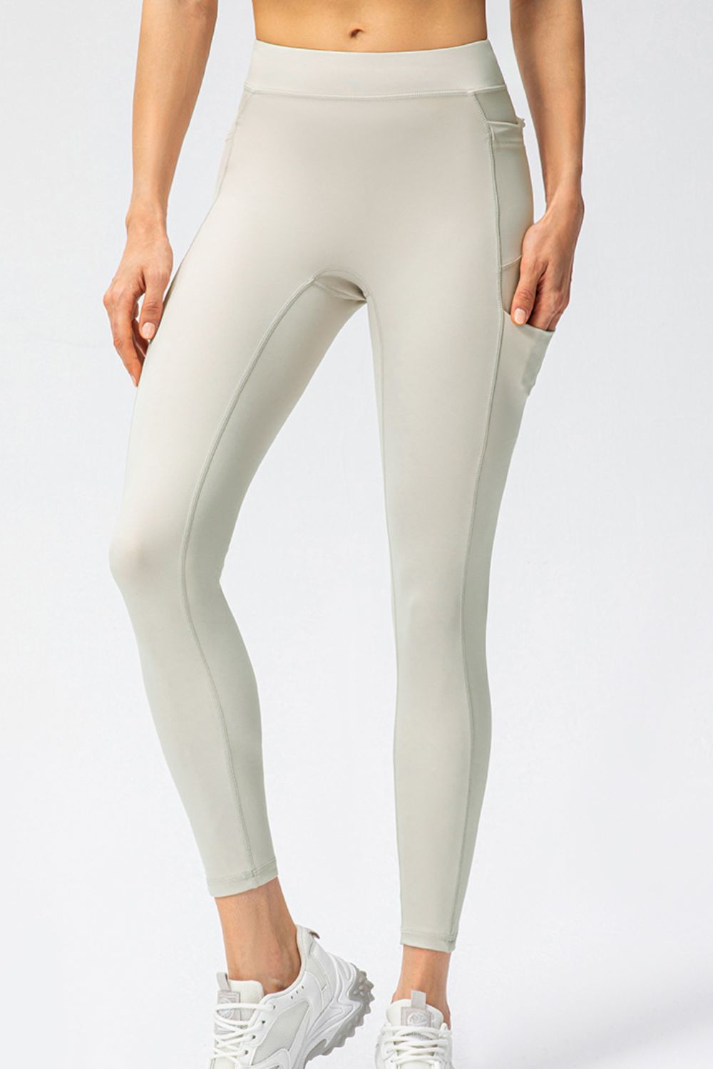 Close view of ivory high-waist leggings with side pocket and phone