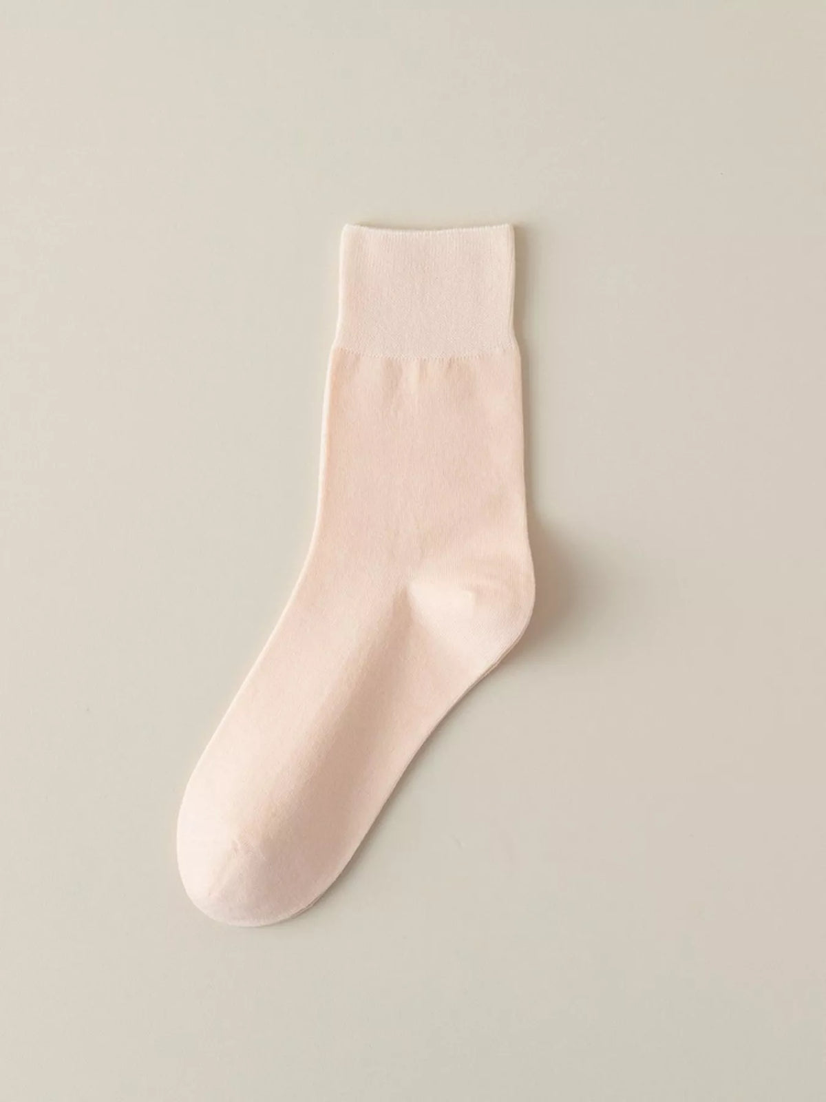 Pale pink solid-color crew sock displayed flat