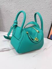 Teal crossbody bag angled to show front and side panels