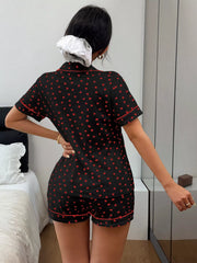 Model seated in black pajamas with scattered red hearts