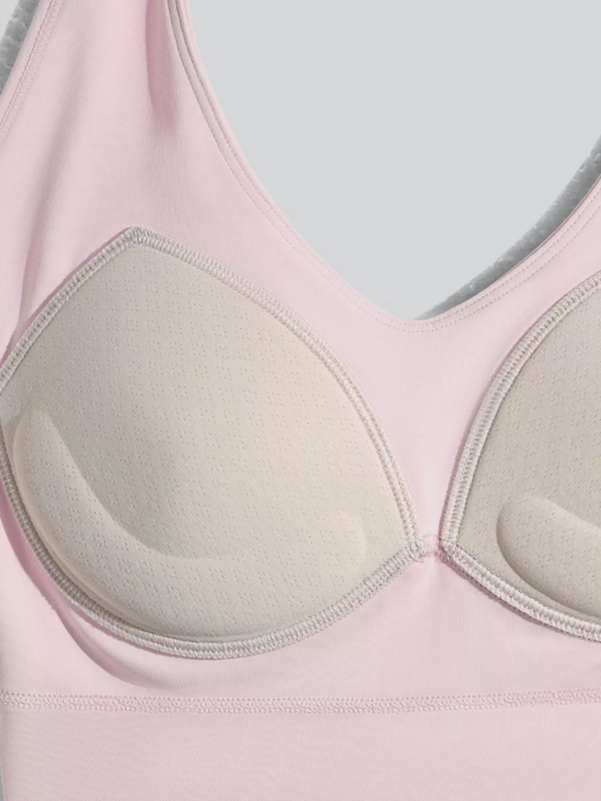 Inside of the pink active bra showing shaped cup lining and a removable pad.