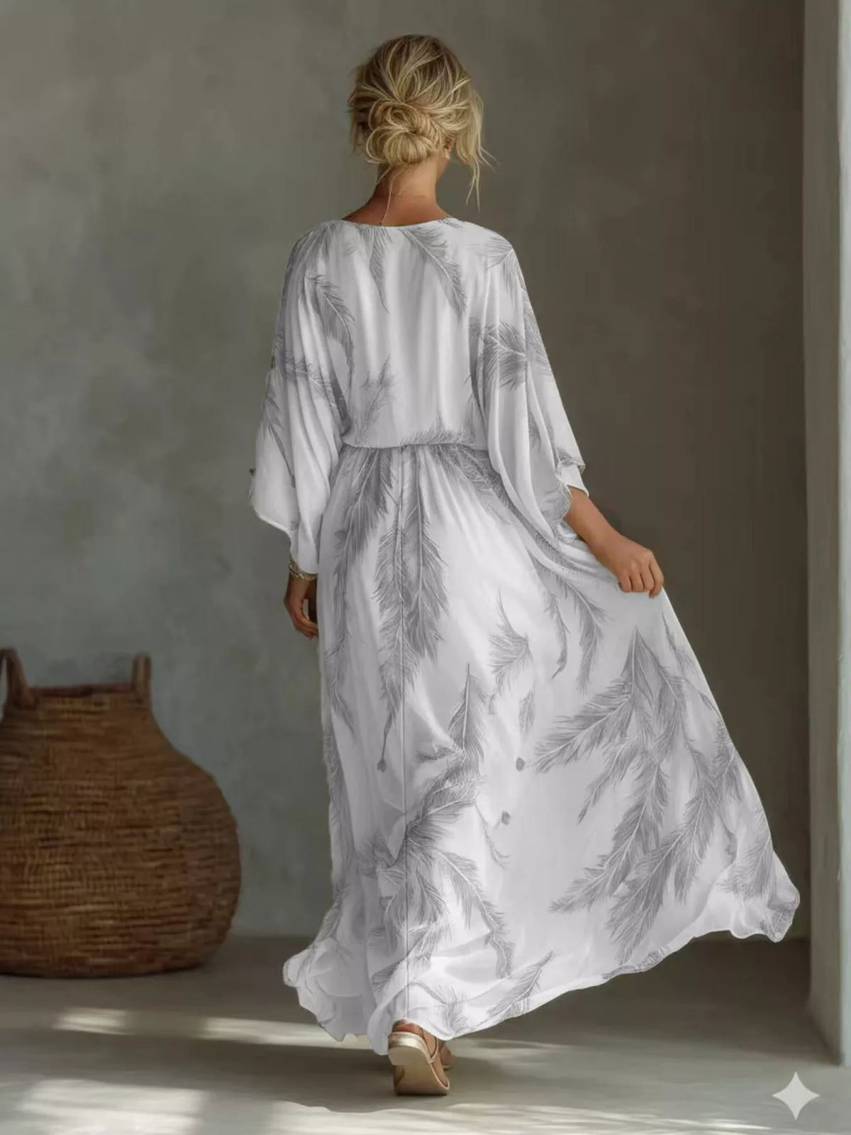 Back view of the grey feather-print maxi dress with loose sleeves and a gathered waist.